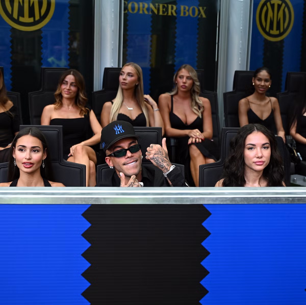 Sfera Ebbasta in dello skybox de San Siro durante la partita, circondaa de bagaj vestii de negher